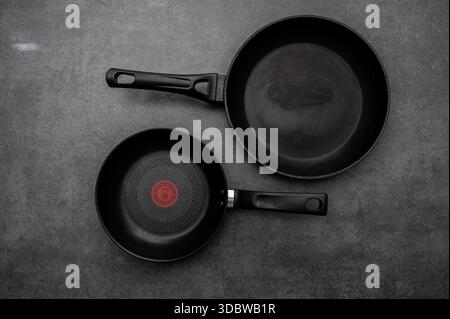Comparison of pans. Old and new frying pan. New and old damaged non-stick coating. Stock Photo