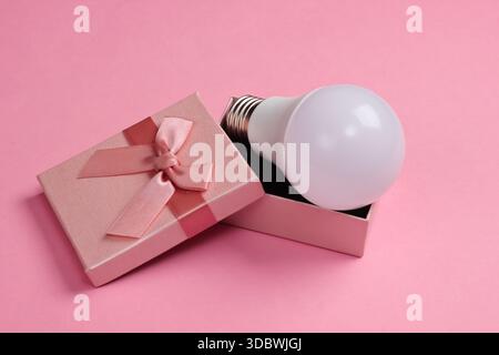 LED light bulb in a gift box on a pink background Stock Photo