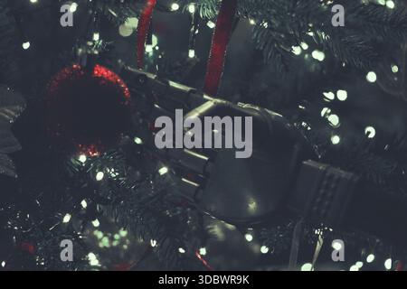 Futuristic Christmas tree with a humanoid robot hand holding a shiny and glitter futuristic black ornament with blue light and circuit print putting i Stock Photo
