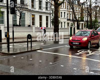 London, UK. 18 December 2025. Pedestrians use umbrellas as traffic moves through rain-soaked streets in central London following heavy downpours. Wet roads and reflections are seen during unsettled weather in the capital. Credit: Alexander Seale/Ģ����ý Live News Stock Photo
