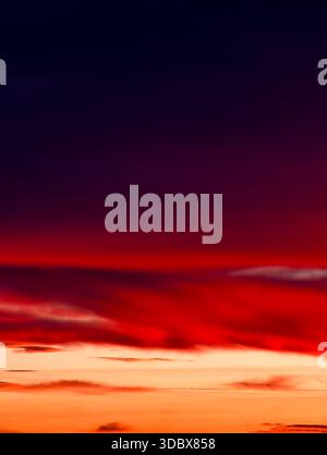 Sunset Sky with Dramatic Red Clouds and Dark Horizon Abstract Orange Gradient Soft Motion Blur Warm Atmospheric Tones Digital Nature Background Stock Photo