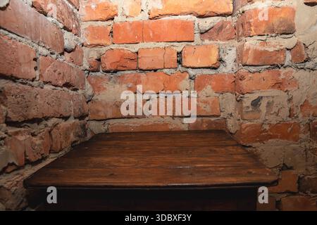 Empty wooden table against old brick wall interior background with copy space Stock Photo