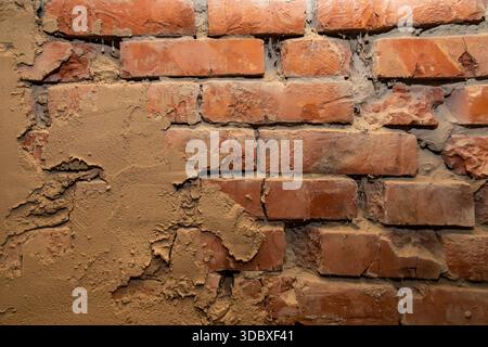 Old brick wall with plaster texture showing rough architectural surface background Stock Photo