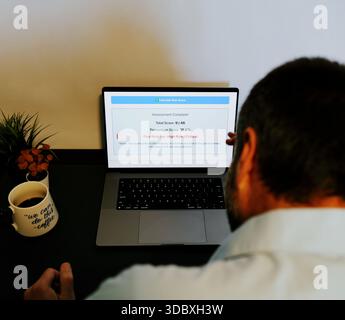Middle Aged Male Cybersecurity Analyst Conducts Third Party Risk Assessment on Outside Vendor Stock Photo