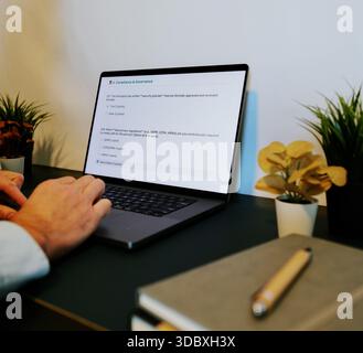 Middle Aged Male Cybersecurity Analyst Conducts Third Party Risk Assessment on Outside Vendor Stock Photo