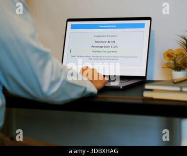 Middle Aged Male Cybersecurity Analyst Conducts Third Party Risk Assessment on Outside Vendor Stock Photo