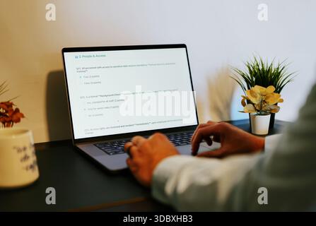 Middle Aged Male Cybersecurity Analyst Conducts Third Party Risk Assessment on Outside Vendor Stock Photo