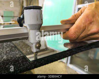 Using a manual high-speed cutter to cut glass Stock Photo