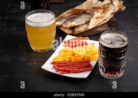 Beer and snack, chips and kabanos on a dark background. Stock Photo