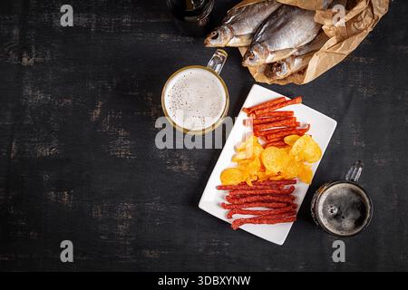 Beer and snack, chips and kabanos on a dark background. Stock Photo