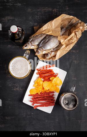 Beer and snack, chips and kabanos on a dark background. Stock Photo