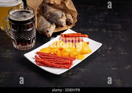Beer and snack, chips and kabanos on a dark background. Stock Photo