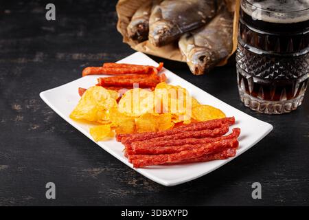 Beer and snack, chips and kabanos on a dark background. Stock Photo
