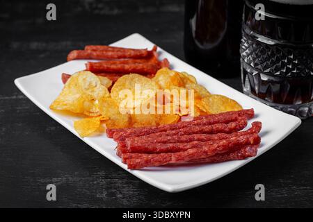 Beer and snack, chips and kabanos on a dark background. Stock Photo