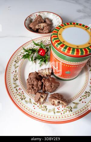 Pieces of panettone with melted chocolate next to a tin of cookies vertical. Stock Photo