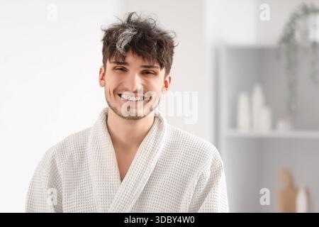 Young man with graying hair smiling in bathroom Stock Photo