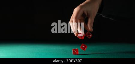 Hand throwing game dices on green background with space for text Stock Photo