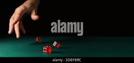 Hand throwing game dices on green background with space for text Stock Photo