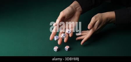 Hands throwing game dices on green background with space for text Stock Photo