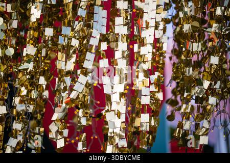 Golden reflective hanging decorations form an abstract festive pattern with soft lights glowing in the background Stock Photo