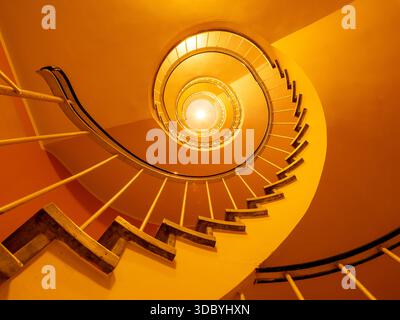 Golden Spiral Staircase in Munich - Symmetrical Circular Stairwell Viewed from Below with Warm Light Stock Photo