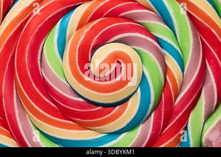 Colorful rainbow lollipop swirl on wooden stick isolated on white background Stock Photo