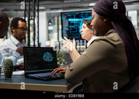 IT experts doing brainstorming in company conference room, implementing AI solutions to increase productivity. Technicians discussing deep learning models roadmap in startup office Stock Photo