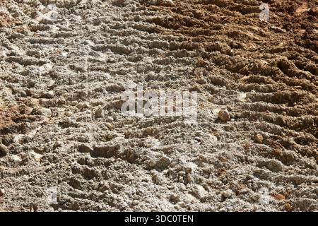 Rough textured soil surface with deep tire track imprint on uneven brown ground showing abstract pattern and tough messy grainy backdrop of constructi Stock Photo