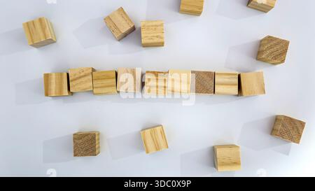 Wooden Blocks Forming Line with Scattered Cubes on White Background Stock Photo