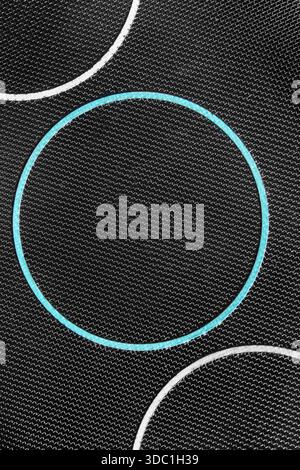 Ring shaped light blue frame on black netting fabric background closeup Stock Photo