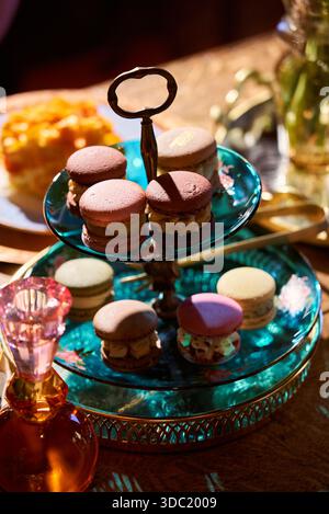 A tiered stand holds various types of macarons in different colors Stock Photo