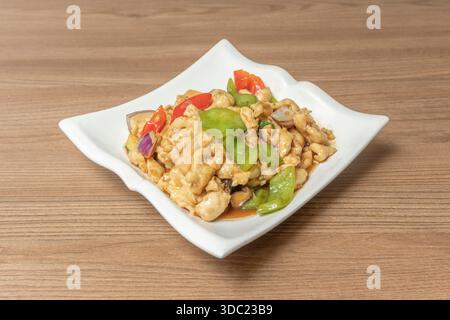Kung Pao Chicken with diced red and green bell peppers, peanuts, and cashews, with a slightly thickened sweet and sour sauce, served over noodles Stock Photo