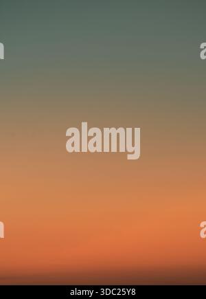 Soft late afternoon sky illuminated by sunset light, forming a minimal and calming background with subtle dramatic atmosphere. Stock Photo