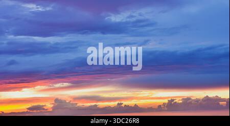 Nature's dramatic seal: beautiful, saturated colors exploding across the light cloud cover. Evokes feelings of peace, warmth, and natural wonder. Stock Photo