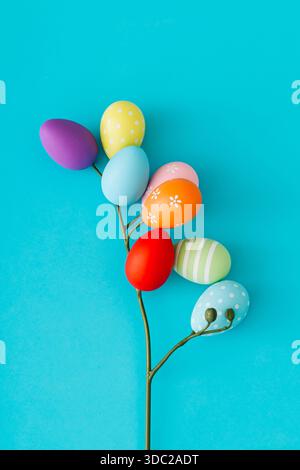 Spring composition with flower made of Easter eggs on pastel blue background. Easter concept. Creative festive holiday layout. Easter aesthetic. Stock Photo