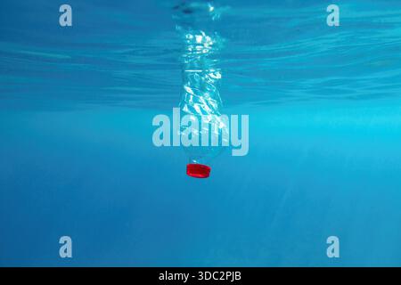 Plastic bottle floating in the blue sea water. World ocean contaminated by  plastic. Environment pollution concept. Stock Photo