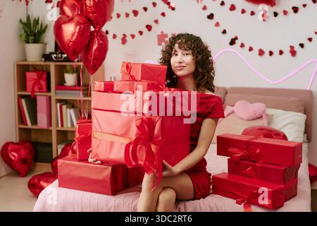 Portrait of Young Adult Woman Smiling While Holding Valentine Gifts Stock Photo