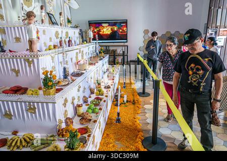 Puebla Mexico,Day of the Dead Dia de Muertos altar ofrenda,indoor cultural exhibit,traditional offerings food candles marigold flowers,people adults H Stock Photo