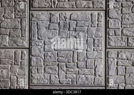 Abstract geometric pattern of grey brick and stone squares on wall. Stock Photo