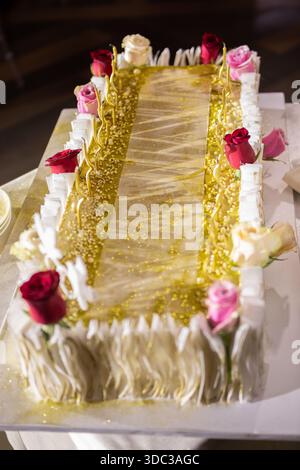 A trendy long wedding cake with glitter and waffle paper. Stock Photo