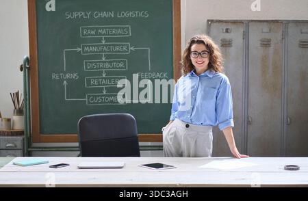 Young happy woman professional teacher in classroom worldwide trade course. Stock Photo