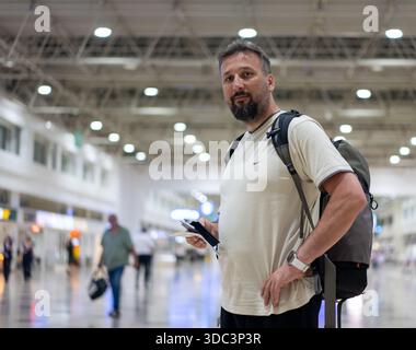 Traveler in airport on his phone checking the directions for his flight. High quality photo Stock Photo