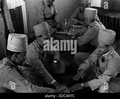 Troopers of the Spahi Cavalry engaging in one of their favorites pastimes of playing chequers, during which they drink large quantities of cold, sweet Stock Photo