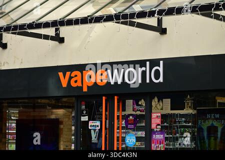 Lichfield, UK - December 10, 2025: Vapeworld storefront orange logo black sign with window displays Stock Photo