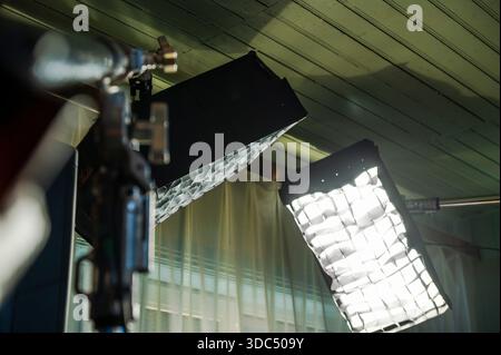 Professional studio lighting softboxes with grids illuminating a film production set, showing essential equipment for video and photography shoots and Stock Photo