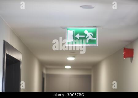 Exit sign in a hallway showing direction to safety Stock Photo