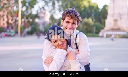Happy diverse couple embracing outdoors in city Stock Photo