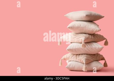 Stack of decorative pillows on pink background Stock Photo