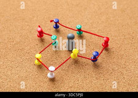 Connected pins with thread and figure on board. Link concept Stock Photo