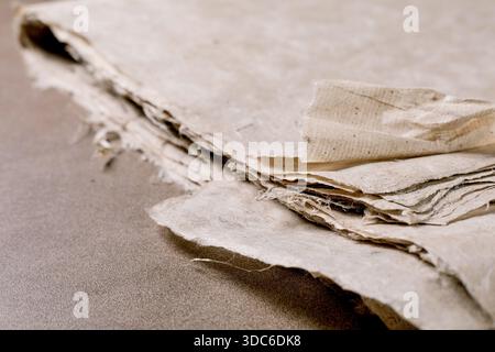 Closeup vintage mulberry paper sheets with torn edges textured surface natural beige color on neutral background. Antique document fragments handcraft Stock Photo